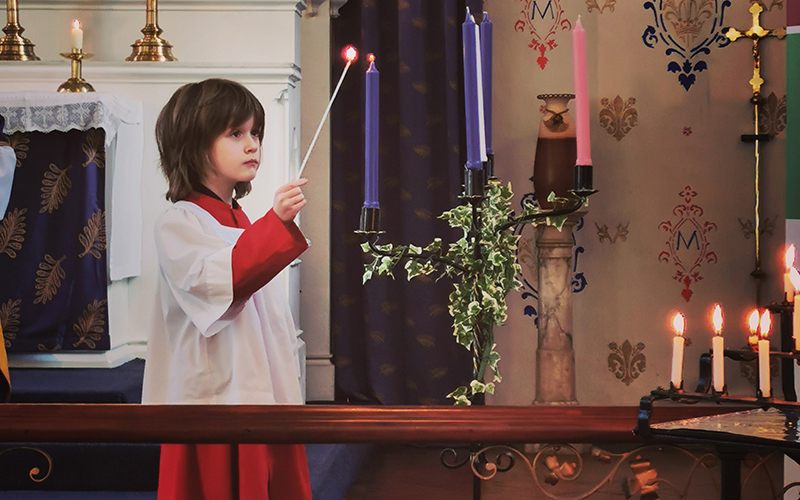 Child lighting a candle in Church